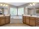 Bathroom with double sinks, wood cabinetry, soaking tub and natural light at 4765 Silver Leaf Dr, Cumming, GA 30040
