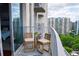 Balcony features seating area with stunning views of surrounding city buildings and lush greenery at 860 Peachtree Ne St # 1411, Atlanta, GA 30308