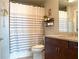 Bathroom featuring a granite-topped vanity, framed mirror, and a shower-tub combo with a striped curtain at 860 Peachtree Ne St # 1411, Atlanta, GA 30308