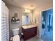 Bathroom featuring a granite-topped vanity, framed mirror, and a shower-tub combo with a striped curtain at 860 Peachtree Ne St # 1411, Atlanta, GA 30308