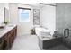 Bright bathroom featuring double vanity, soaking tub, glass enclosed shower, and modern fixtures at 1248 Windmill Pkwy # 240, Cumming, GA 30041