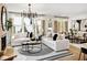 Bright living room features large windows, fireplace, modern chandelier, and open floor plan at 1248 Windmill Pkwy # 240, Cumming, GA 30041