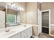 Bright bathroom vanity with double sinks, a soaking tub with a window view, and access to a walk-in closet at 65 Wisteria Blvd, Covington, GA 30016