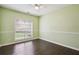 Bedroom features a ceiling fan, a large window for natural light, and laminate wood flooring at 65 Wisteria Blvd, Covington, GA 30016