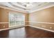 Bedroom with hardwood floors, tray ceiling with ceiling fan, a large window and neutral paint at 65 Wisteria Blvd, Covington, GA 30016