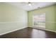 Bedroom features a ceiling fan, a large window for natural light, and laminate wood flooring at 65 Wisteria Blvd, Covington, GA 30016