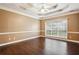 Bedroom with hardwood floors, tray ceiling with ceiling fan, a large window and neutral paint at 65 Wisteria Blvd, Covington, GA 30016