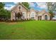 Charming home featuring a manicured lawn, elegant architectural details, and tasteful landscaping at 65 Wisteria Blvd, Covington, GA 30016