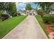 Inviting single-story home featuring a large driveway, manicured lawn, and lush landscaping at 65 Wisteria Blvd, Covington, GA 30016