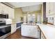 Eat-in kitchen features stainless steel appliances, white cabinets, and a breakfast nook with plenty of windows at 65 Wisteria Blvd, Covington, GA 30016
