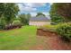 Spacious side yard featuring lush grass and a brick retaining wall, perfect for gardening at 65 Wisteria Blvd, Covington, GA 30016