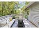 Back deck featuring modern outdoor seating and a view of the surrounding trees at 6595 Oakwood Dr, Douglasville, GA 30135
