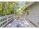 Back deck featuring stained wood, white railing, and view of many trees at 6595 Oakwood Dr, Douglasville, GA 30135
