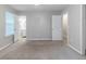 Neutral carpeted bedroom with open door to bathroom with a window at 6595 Oakwood Dr, Douglasville, GA 30135