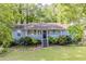 Charming single-story home with a welcoming front porch and a beautifully landscaped front yard at 6595 Oakwood Dr, Douglasville, GA 30135