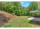 Spacious backyard with mature trees and a landscaped area offers privacy and a natural setting at 209 Wildwood Way, Canton, GA 30114