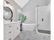 Bright bathroom with a soaking tub, glass shower, and white vanity with marble countertops at 209 Wildwood Way, Canton, GA 30114