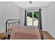 Cozy bedroom with a large window, offering natural light and a pleasant view of the yard at 209 Wildwood Way, Canton, GA 30114