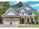 Beautiful two-story home featuring stone accents, a two-car garage, and a welcoming front porch at 209 Wildwood Way, Canton, GA 30114