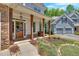 Charming front porch with stone columns, wood door, bench and landscaped walkway at 209 Wildwood Way, Canton, GA 30114