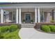 Inviting front porch with white columns, stylish hanging lights, and a cozy porch swing for relaxing outdoors at 3264 Andante Ne Dr, Marietta, GA 30062