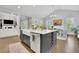 Bright, open kitchen featuring a farmhouse sink, stainless steel dishwasher, and wine storage in the gray kitchen island at 3264 Andante Ne Dr, Marietta, GA 30062