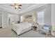 Spacious and bright main bedroom with a trey ceiling, plush carpet, a ceiling fan and a seating area by a window at 3264 Andante Ne Dr, Marietta, GA 30062
