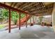 Covered patio with red support posts, adjacent to a lawn area with a playset and lush landscaping at 4085 Tritt Homestead Dr, Marietta, GA 30062