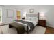 Comfortable bedroom featuring a bed with neutral bedding, two side tables and an outdoor deck access at 4085 Tritt Homestead Dr, Marietta, GA 30062