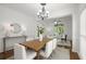 Stylish dining area with wood table, white chairs, and view to the office at 4085 Tritt Homestead Dr, Marietta, GA 30062