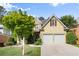 Inviting home exterior with stone accents, two-car garage, and lush green lawn at 4085 Tritt Homestead Dr, Marietta, GA 30062