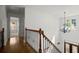 Upstairs hallway features hardwood floors, wood railings, and a hanging chandelier light fixture at 4085 Tritt Homestead Dr, Marietta, GA 30062