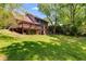 Expansive backyard featuring a deck and lush green space, surrounded by mature trees at 5124 Vermack Rd, Dunwoody, GA 30338