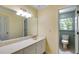This bathroom features a single sink vanity, toilet with window view, and tile flooring at 5124 Vermack Rd, Dunwoody, GA 30338