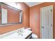 Powder room includes traditional vanity, neutral paint, and decorative mirror at 5124 Vermack Rd, Dunwoody, GA 30338