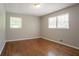 Bedroom with hardwood floors, two windows, and neutral colored walls at 802 San Miguel Dr, Stone Mountain, GA 30083