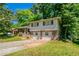Exterior view of split-level home with a two-car garage, front porch, and mature trees at 802 San Miguel Dr, Stone Mountain, GA 30083