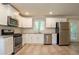 Bright kitchen with white cabinets, subway tile backsplash, stainless steel appliances, and light flooring at 802 San Miguel Dr, Stone Mountain, GA 30083
