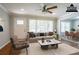 Staged living room with neutral colors, large windows, ceiling fan, and hardwood floors at 802 San Miguel Dr, Stone Mountain, GA 30083
