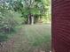 Spacious backyard featuring manicured lawn and privacy from mature trees at 947 Meadow Rock Dr, Stone Mountain, GA 30083