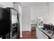 Kitchen with black backsplash, stainless fridge and modern white cabinets at 3324 Peachtree Ne Rd # 1304, Atlanta, GA 30326