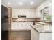 Clean kitchen with white cabinets, tiled backsplash, and black appliances at 4981 Forestglade Ct, Stone Mountain, GA 30087