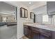 Bathroom featuring double sinks and dark cabinets, with a glimpse into the main bedroom at 548 Azalea Bloom Drive E, Loganville, GA 30052