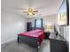 Well-lit bedroom with a ceiling fan, large TV, and gray carpet flooring at 548 Azalea Bloom Drive E, Loganville, GA 30052