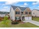 Well-maintained home with a two-car garage, neat landscaping, and classic brick and siding exterior at 548 Azalea Bloom Drive E, Loganville, GA 30052