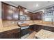 Modern kitchen with granite countertops, dark cabinets, and stainless steel microwave at 548 Azalea Bloom Drive E, Loganville, GA 30052