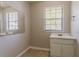 A well-lit bathroom features a vanity, mirror, and a window with blinds for natural light at 1074 Cherokee Hts, Stone Mountain, GA 30083