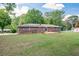 Expansive backyard with a large brick house, wooden deck, and lush green grass at 232 Hembredge Dr, Canton, GA 30115
