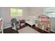 Well-lit Bedroom has hardwood floors, a crib, rocking chair, and a dollhouse at 232 Hembredge Dr, Canton, GA 30115