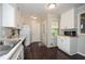 Functional kitchen with white cabinets, stainless steel sink, and dark hardwood floors at 232 Hembredge Dr, Canton, GA 30115